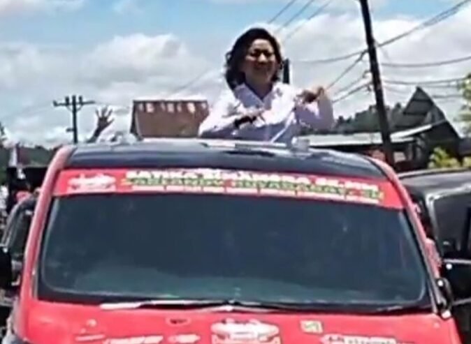 Satika Simamora melambaikan tangan sepanjang jalan saat menuju KPU.