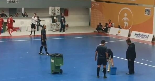 Para Wasit tampak sedang menampungair hujan yang masuk ke GOR Futsal Jalan Pancing karena atapnya bocor.